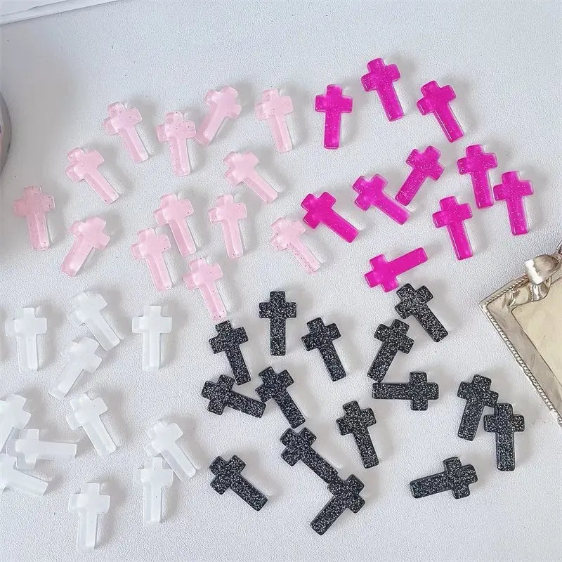 Eine Sammlung von Glitzerkristall-Kreuzdekorationen in verschiedenen Rosa- und Schwarztönen.