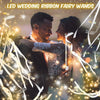 A couple is illuminated by LED wedding ribbon fairy wands with sparkling lights and ribbons.