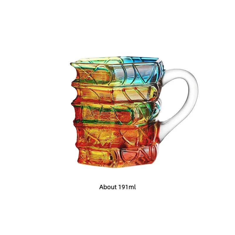 Hand-painted mug featuring layered, vibrant orange and green book designs.