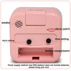 A pink compact alarm clock featuring a speaker, alarm switch, time setting, and battery compartment.