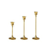 A set of three vintage European style metal candle holders with gold finish.