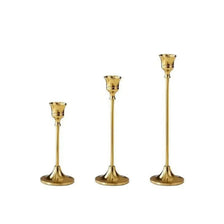 A set of three vintage European style metal candle holders with gold finish.