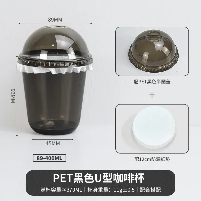 A black disposable U-shaped PET coffee cup with a lid and a white disc.