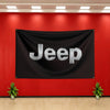 A black banner with the word Jeep in silver lettering hangs on a red wall.