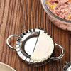 Stainless steel dumpling maker with a crimped edge next to raw meat and tortillas on a wooden surface.