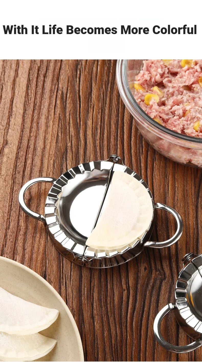 Stainless steel dumpling maker with a crimped edge next to raw meat and tortillas on a wooden surface.