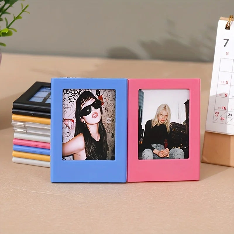 A pair of retro magnetic photo frames in blue and pink, displaying different photographs.