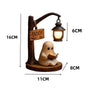 A wooden ghost reading figurine with a hanging lantern decor.