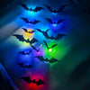 A collection of black bat silhouettes glowing with various colors like blue, green, purple, and red light.