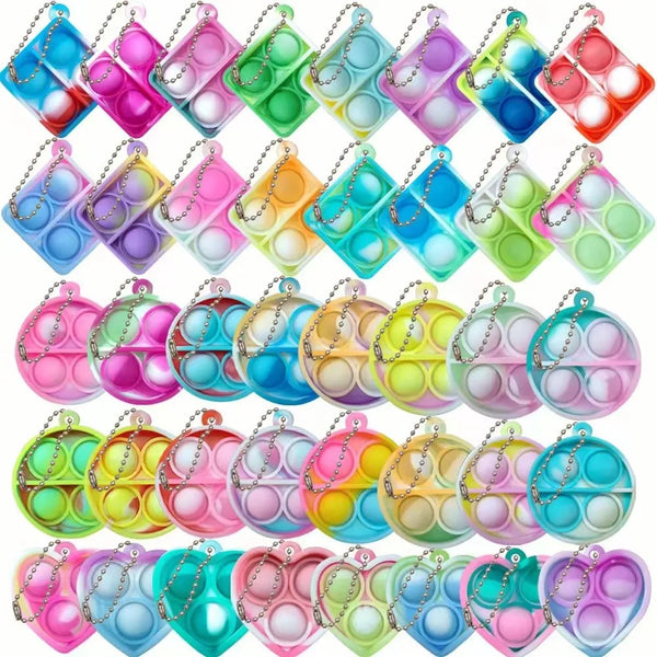 A collection of colorful mini sensory fidget keychains in various shades of pink, green, blue, and yellow.
