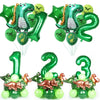 A set of green dinosaur-themed party tableware including banners, balloons, and foliage.