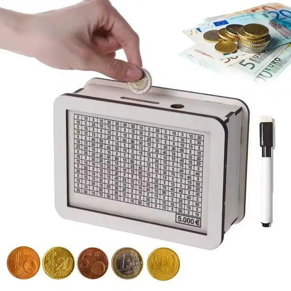 A white wooden money saving box with a grid tracker is shown next to gold coins and paper currency.