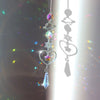 A silver pendant featuring a rainbow sun catcher design with various crystal and gemstone charms.