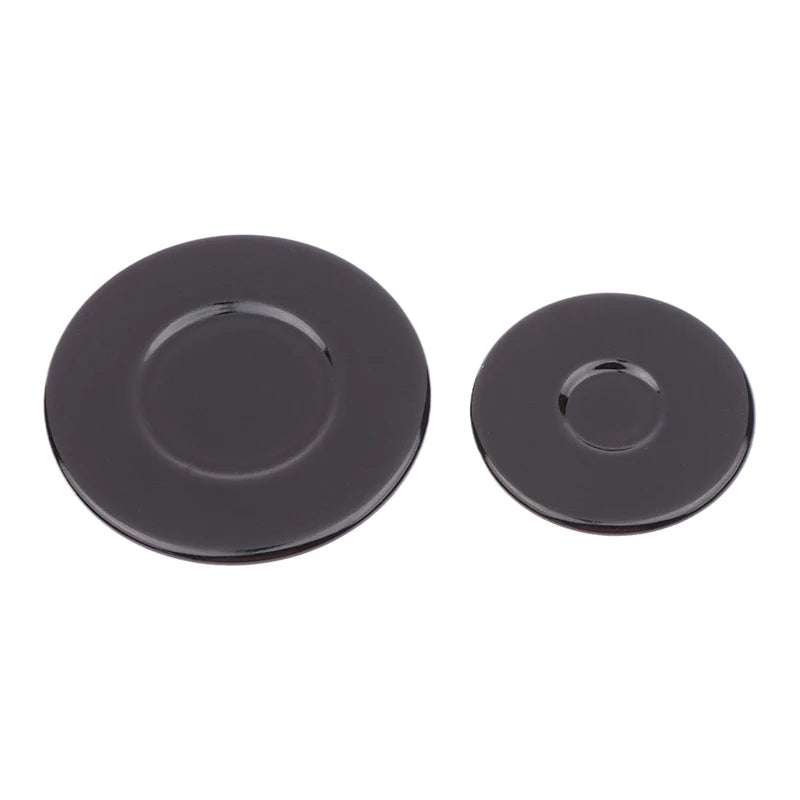 A set of two black gas stove burner caps.