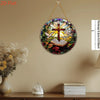 A round crystal sun catcher featuring a cross and dove design hanging on a wall.