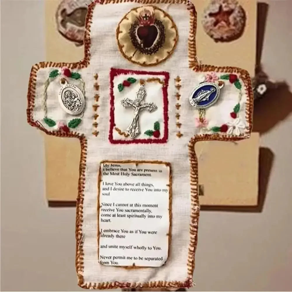 Hand sewn silver prayer pocket decoration shaped like a cross on white fabric