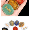 A collection of natural crystal ellipses in various colors including purple, red, green, and gold, displayed on a hand.