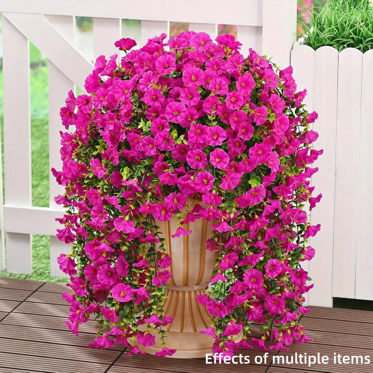 A dense display of vibrant pink artificial morning glory hanging vines in a white planter