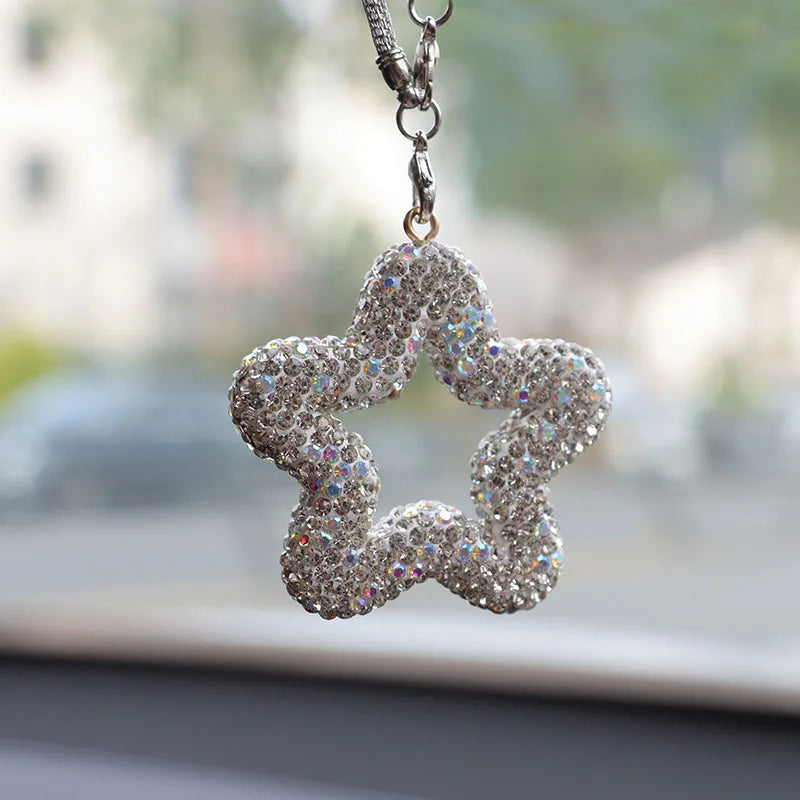 Silver rhinestone star charm hanging from a chain with crystal accents