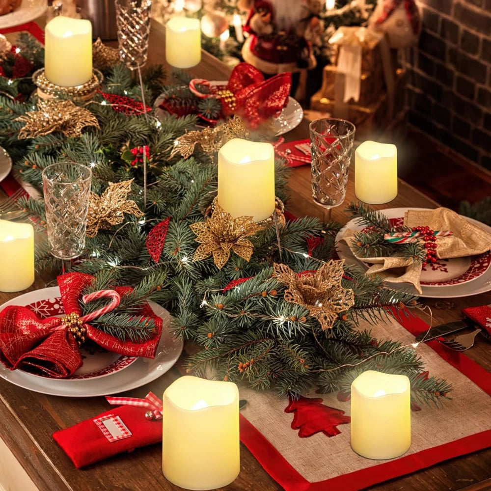 A festive holiday table setting featuring green pine branches, red ribbons, and glowing white LED votive tea lights.