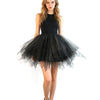 A woman models a black tulle tutu skirt and black top against a white background.