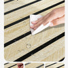 A hand wipes water off a self-adhesive wood grain wallpaper roll, demonstrating its easy to clean and waterproof features.