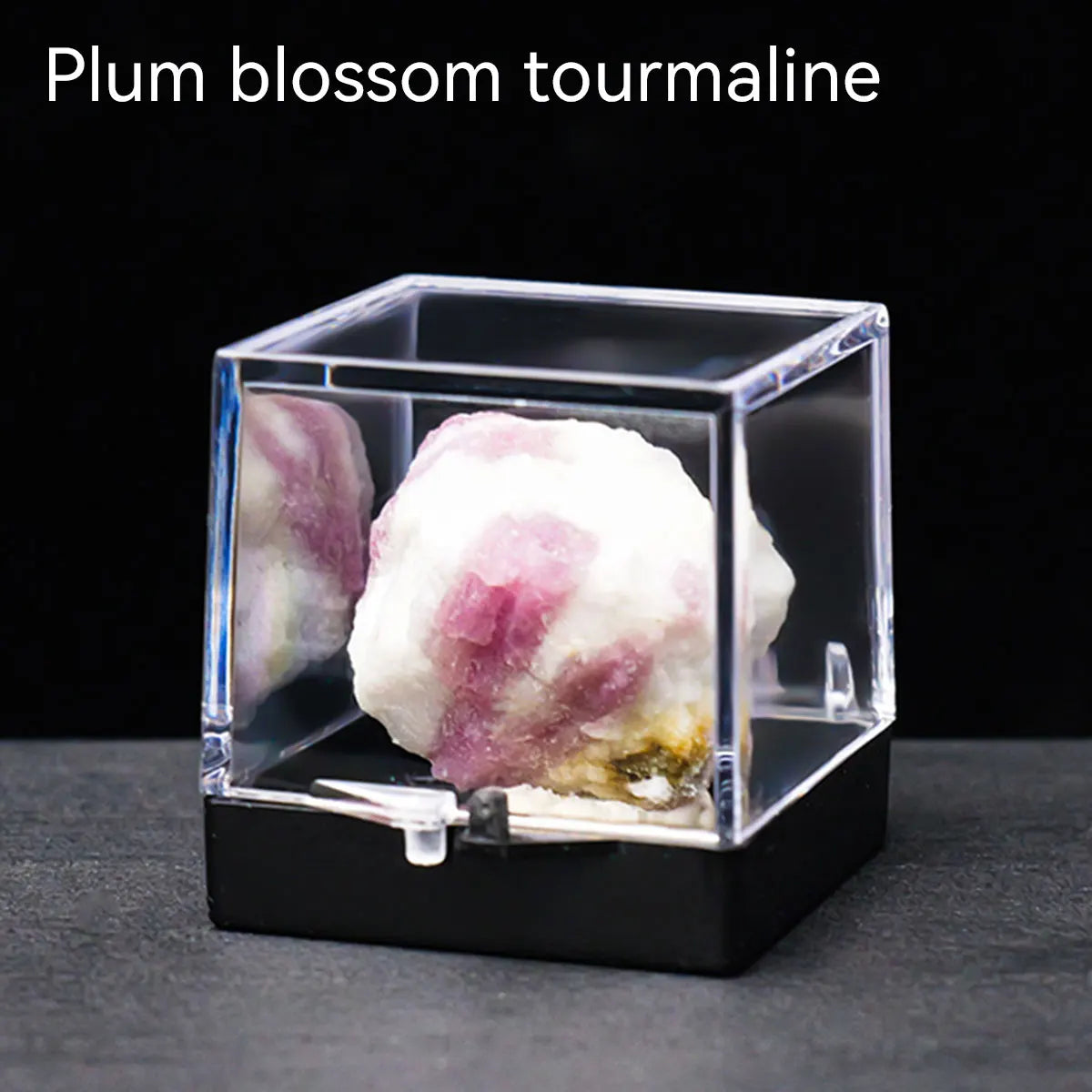 A translucent pink and white plum blossom tourmaline crystal specimen displayed in a clear box.