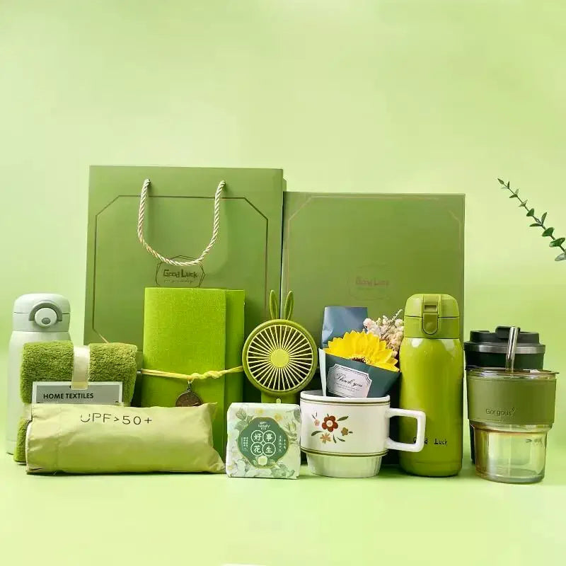 A green gift set featuring a tumbler, towel, and UPF sun protection product on a light green background.