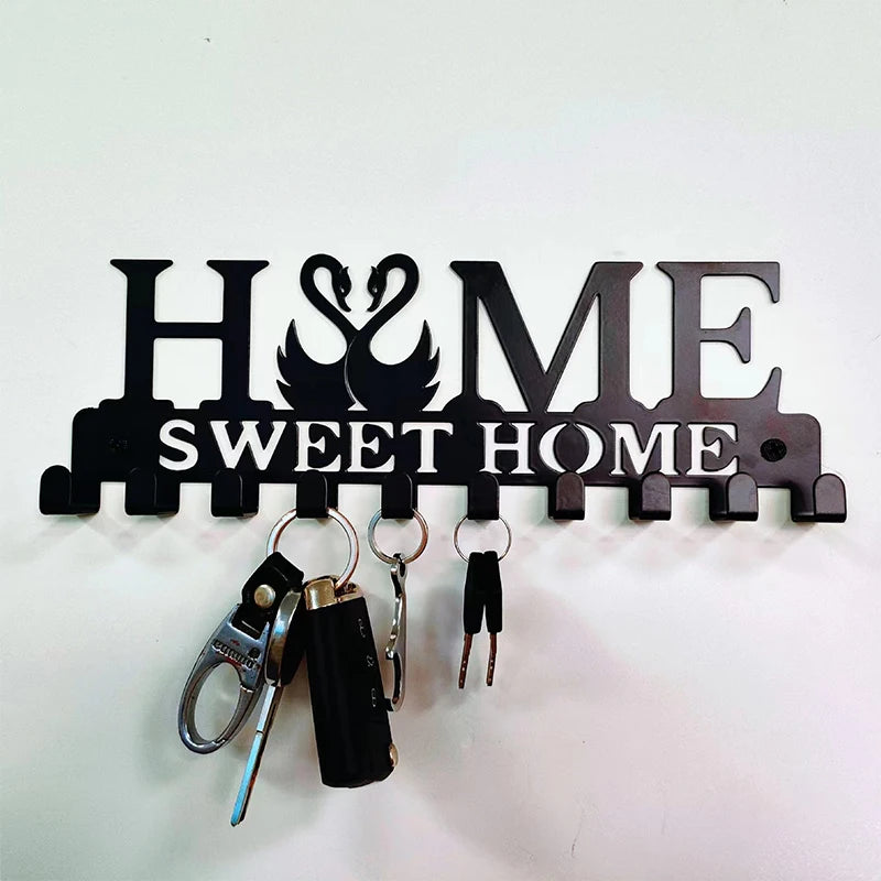 Black metal key holder with wall mounted hooks featuring the initials H&ME and the text Sweet Home