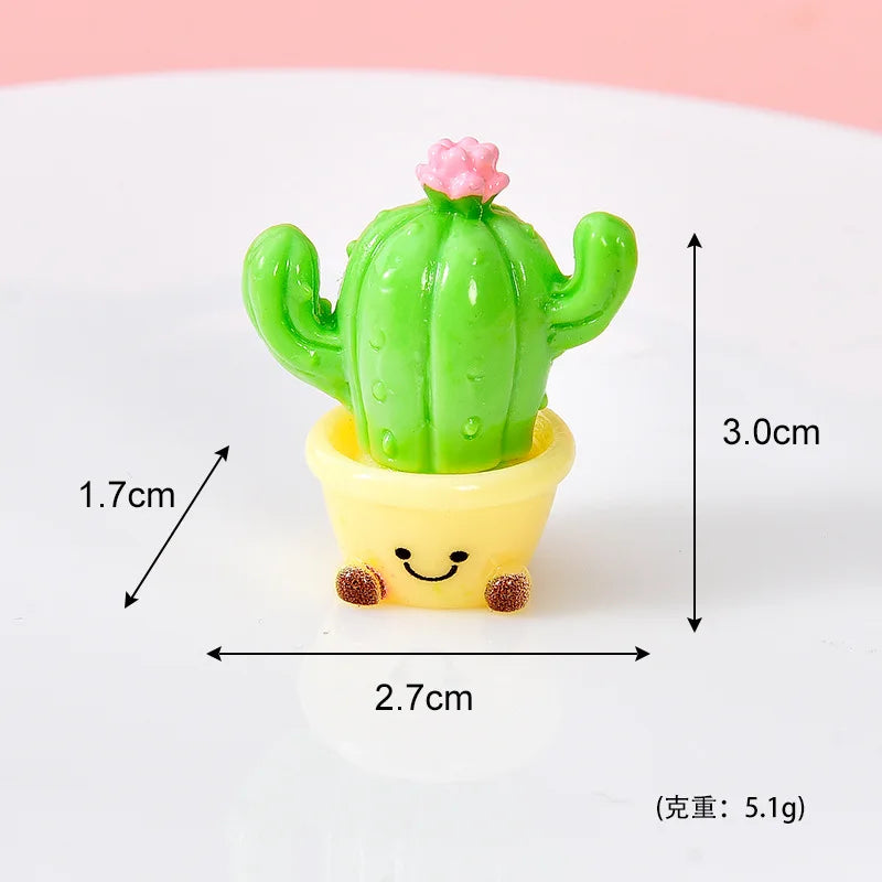 A small green cactus with a pink flower growing out of a yellow pot, used as a resin charm.
