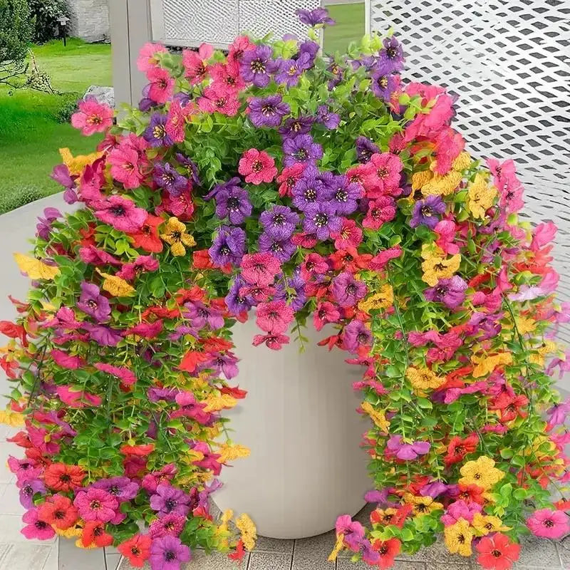 A vibrant archway made of artificial flowers in shades of pink, purple, yellow, and green.