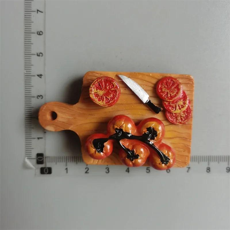 A wooden cutting board displays sliced tomatoes, a knife, and a drizzle of black sauce.