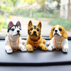 A set of three multi-figure dog ornaments, including a white and black dog, a fawn-colored dog, and a white and tan dog.