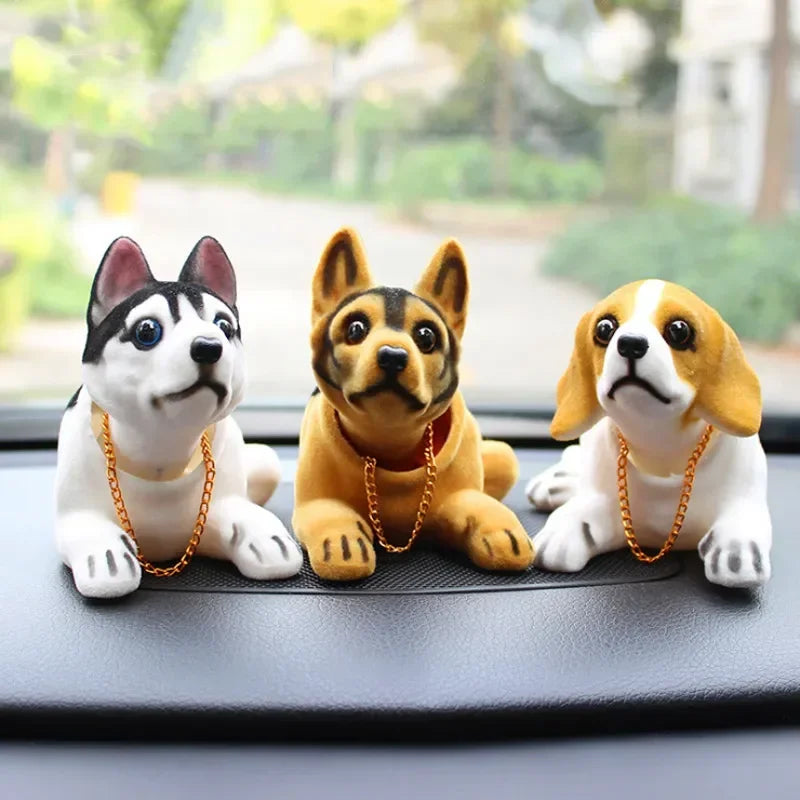 A set of three multi-figure dog ornaments, including a white and black dog, a fawn-colored dog, and a white and tan dog.