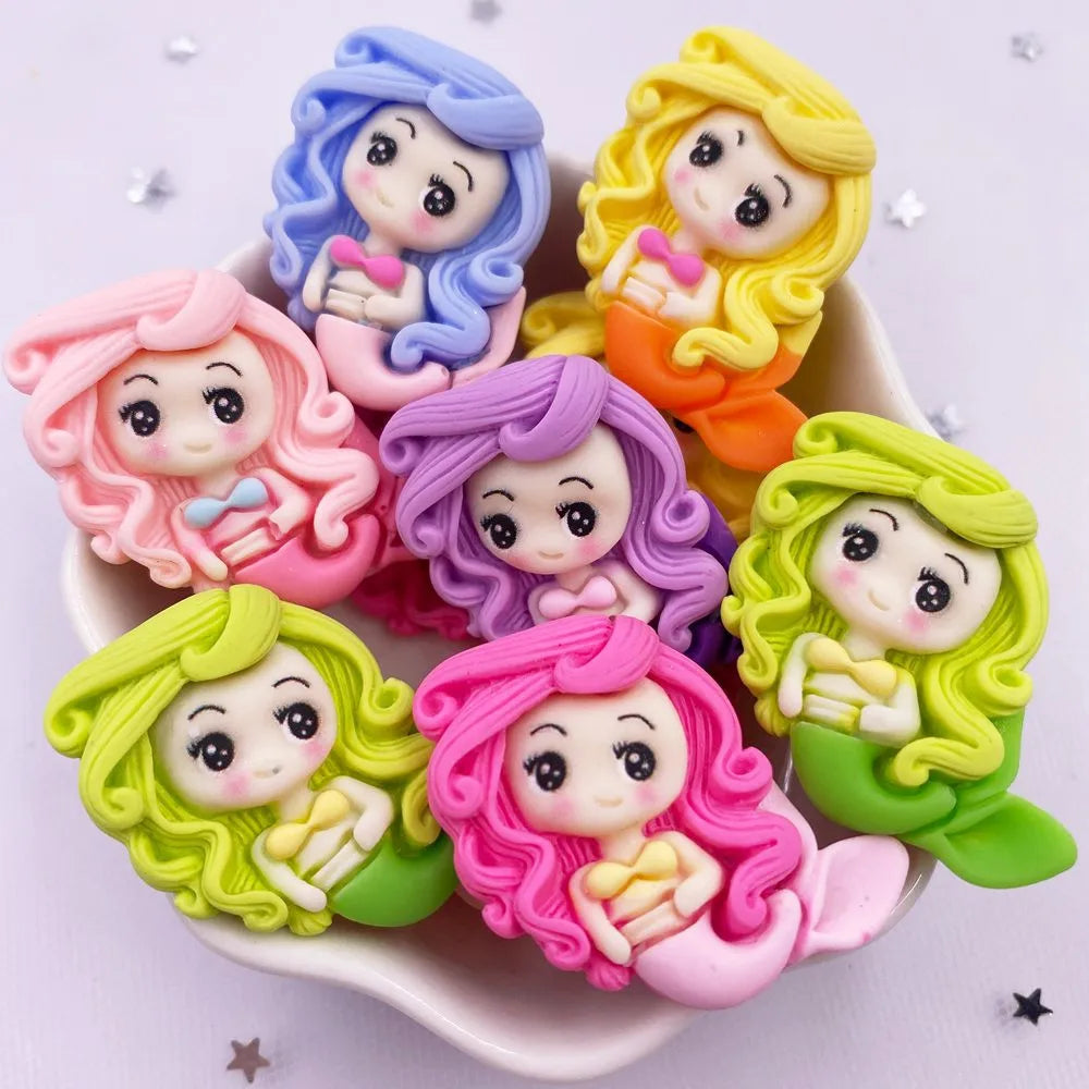 A collection of colorful resin figurines depicting mermaid princesses with curly hair and delicate features.
