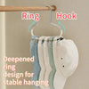 A rack of eight light-colored hats hanging from a ring hook on a wooden rod.