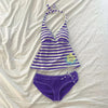 Purple and white striped sleeveless top with tie details laid flat on a white surface.