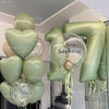 A stack of green and gold foil number balloons shaped like the number 7, celebrating a birthday.