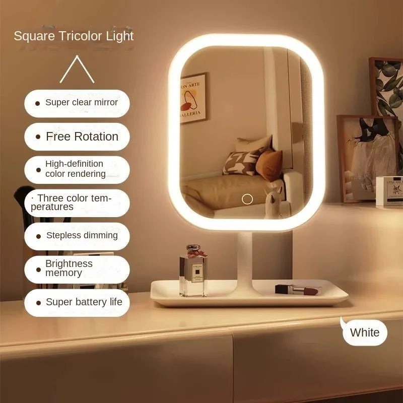 A white square tricolor light vanity mirror with a round LED frame is displayed on a bedside table.