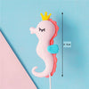 A pink and orange ocean animal cake topper featuring a crab with a crown, set against a blue background.