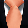 A close-up of an orange silk necktie tied in a knot against a black suit jacket.
