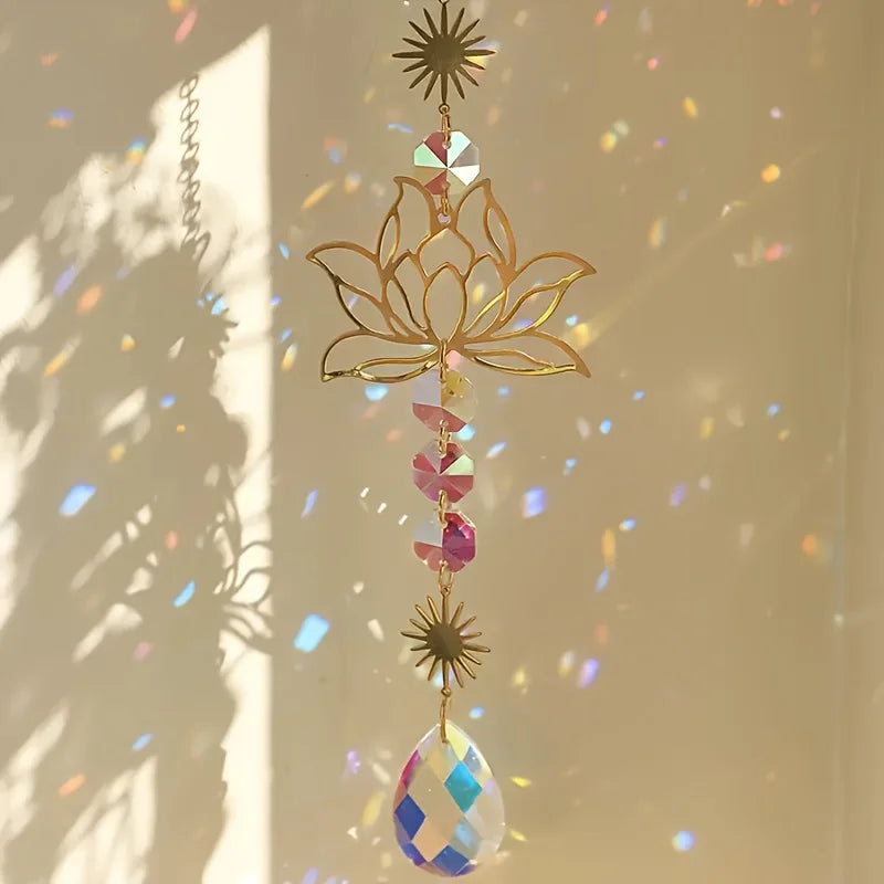 A delicate gold lotus flower crystal glass suncatcher with prism beads and a star charm hanging in sunlight.