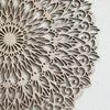 Decoración de pared tipo mandala de madera clara con intrincados recortes en patrón floral circular.