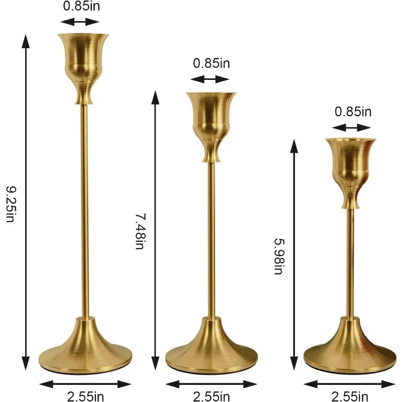 A set of three vintage gold-toned metal candle holders with flared bases and slender stems.