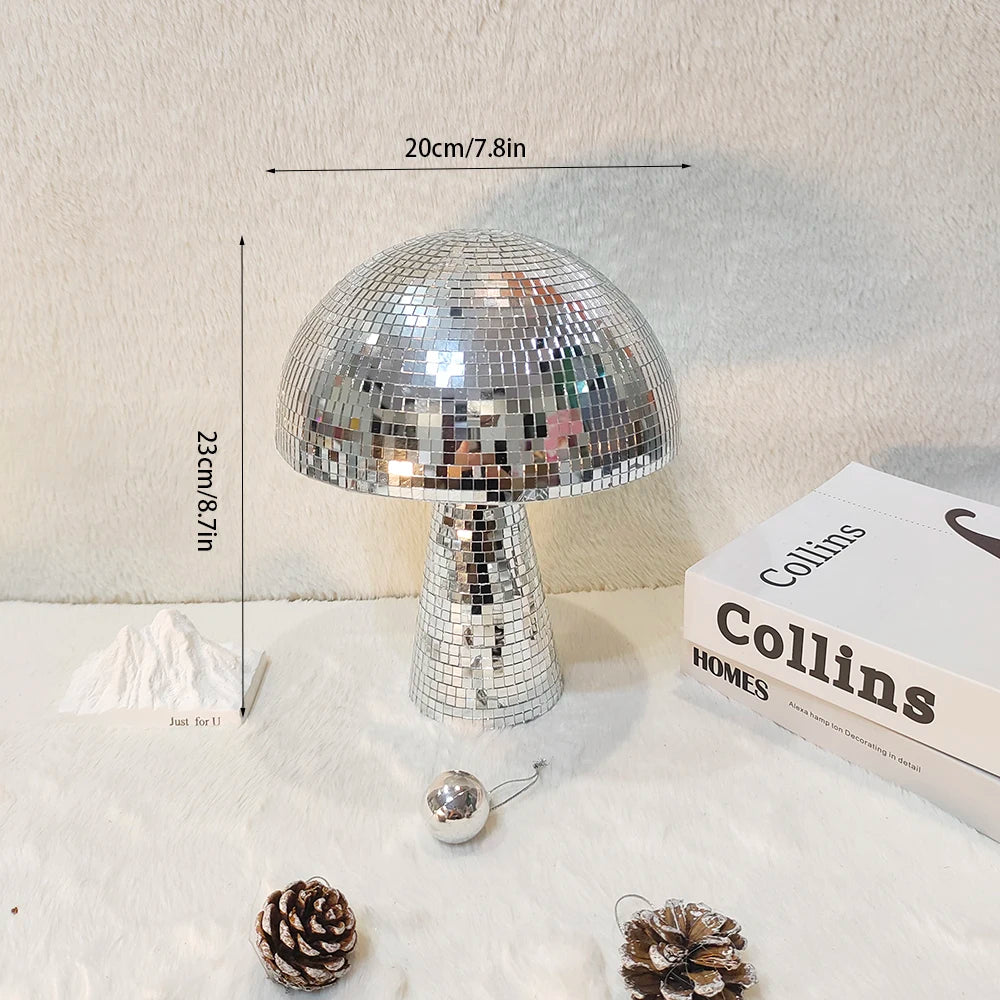 A silver, mushroom-shaped disco ball decoration with a textured surface is displayed on a white surface.