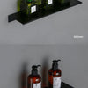 Modern matte black wall shelf displaying several glass bottles with green and black pump dispensers.