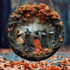 A circular wooden decor sign featuring witches and autumn leaves within a wreath.