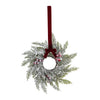A 10-inch artificial Christmas wreath made of green fir branches decorated with red berries and a deep red velvet bow.
