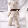 A light beige crocheted stuffed bear with brown accents standing upright.