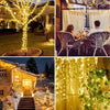 Outdoor string lights illuminating a tree and a couple sitting together in a garden setting.